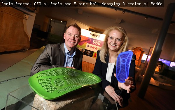 A man and woman display a green and blue plastic insole at a product launch at the Great North Museum