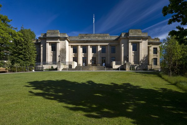 An exterior view of the Great North Museum including a large front lawn